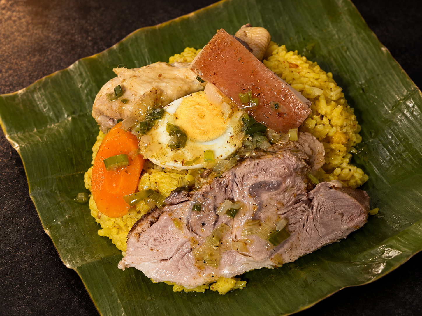 Tamal abierto sobre una hoja de plátano, con carne, zanahoria y medio huevo cocido a la vista.